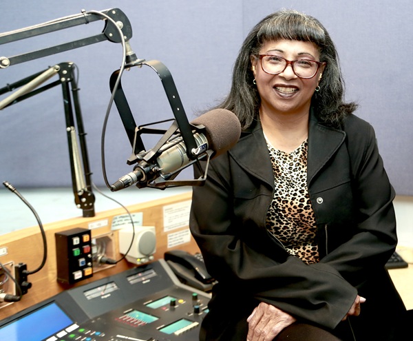 Woman sitting by microphone in radio station